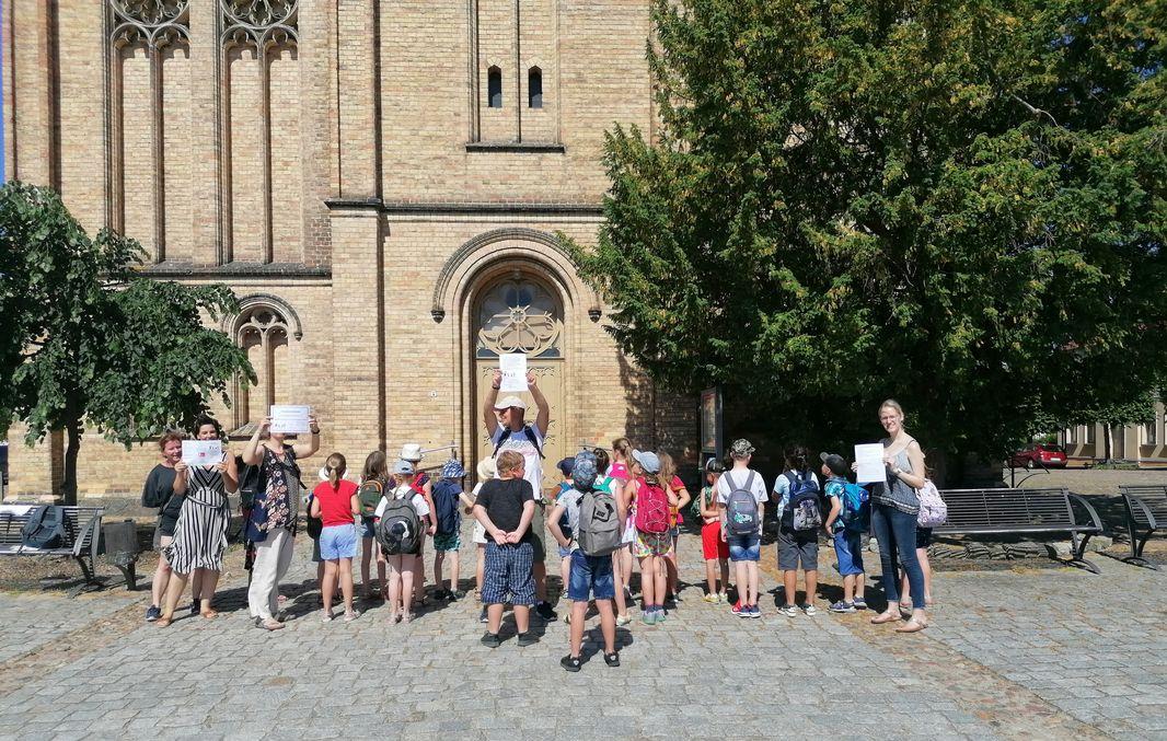 The picture shows children in front of the entrance to the Fürstenberg town church.